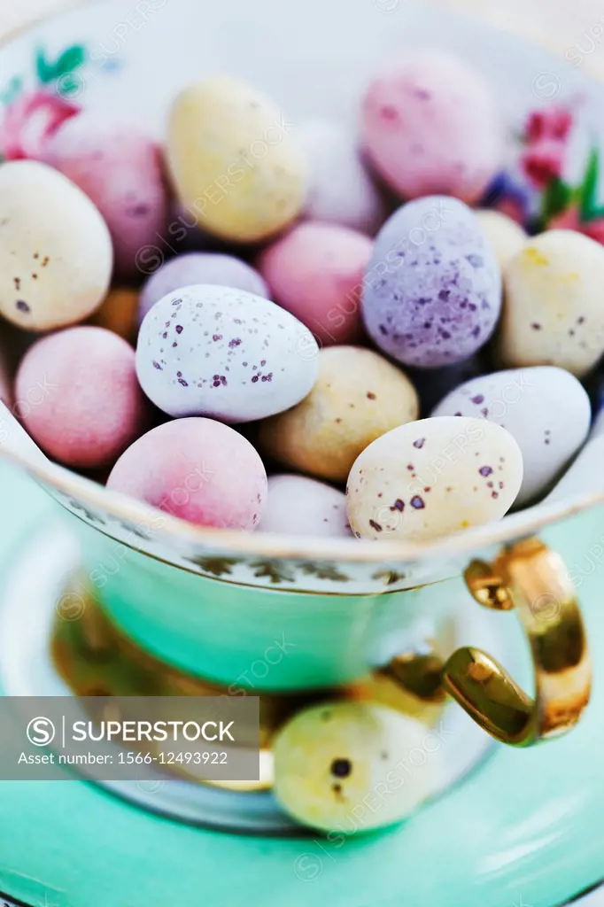 Candy coated chocolate easter eggs in antique china tea cup.