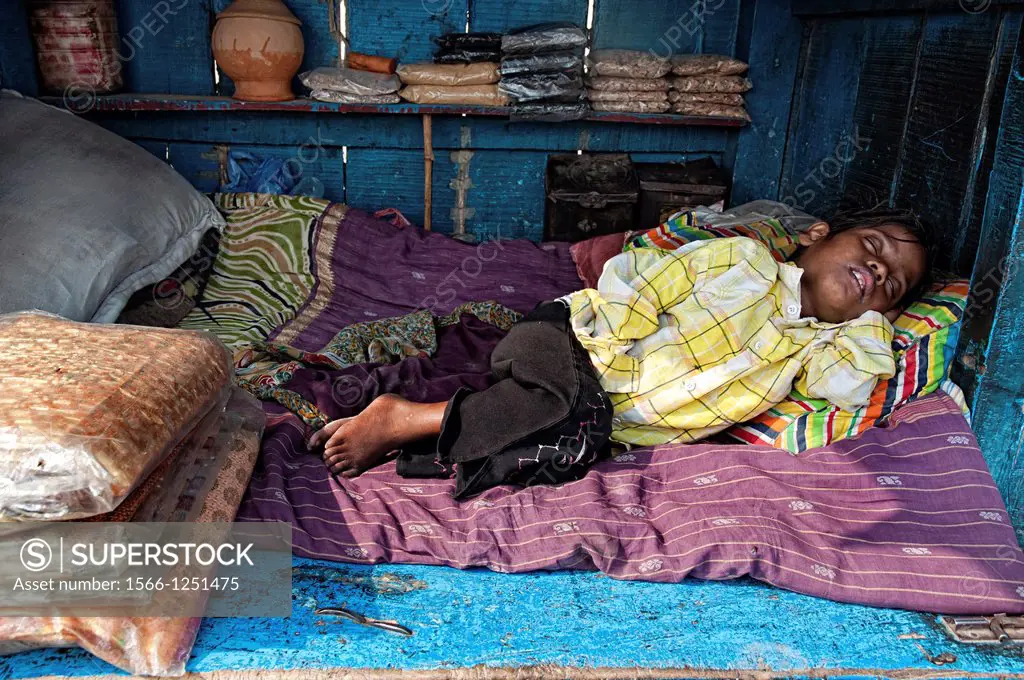 Child sleeping in his little shop, Varanasi, Benares, Uttar Pradesh, India