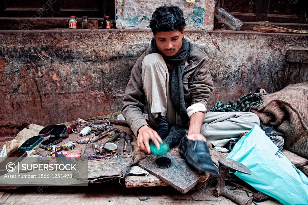 Man polishing shoes in his street stall, Varanasi, Benares, Uttar Pradesh, India