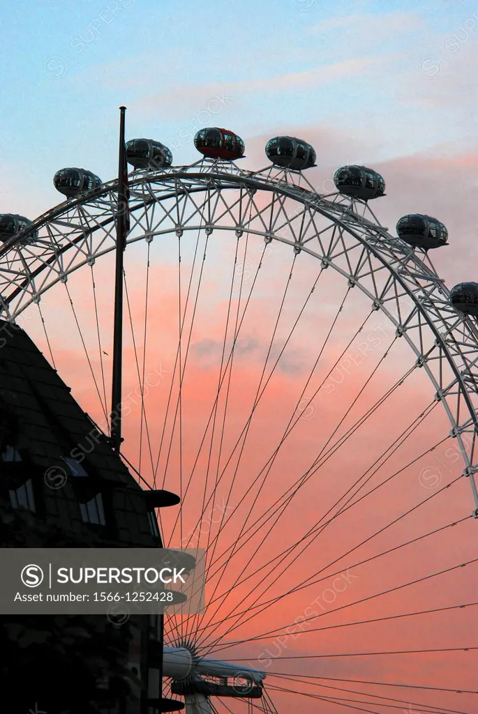 The London Eye seen at sunset in the heart of London, England, with Portcullis House, the annex of the Houses of Parliament in the foreground