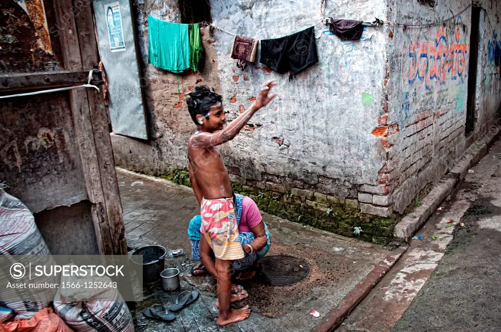 Boy washing himself in the street Calcutta, Kolkata, West Bengal, India