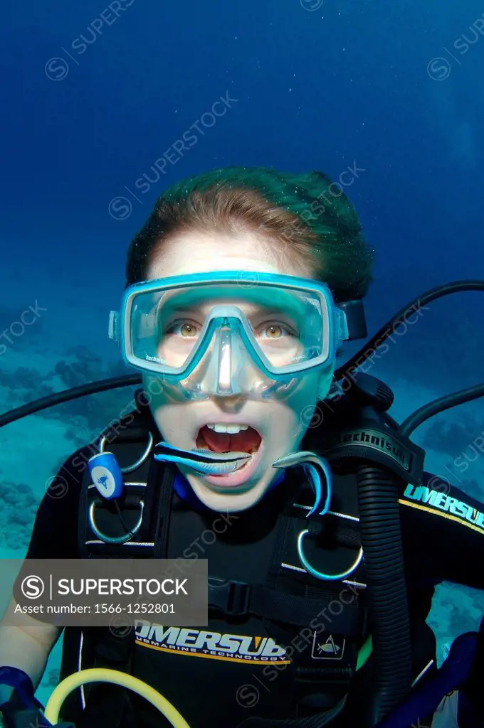 Young diver having mouth cleaned by cleanerfish, Sabre-toothed blenny Aspidontus taeniatus, Red Sea, Egypt, Africa