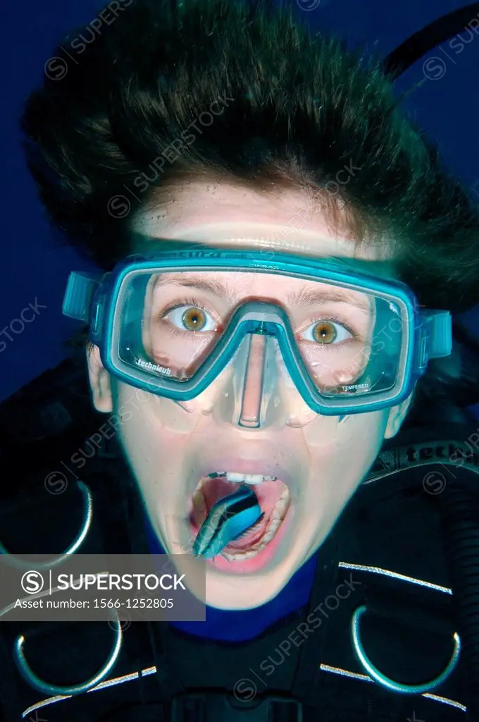 Young diver having mouth cleaned by cleanerfish, Sabre-toothed blenny Aspidontus taeniatus, Red Sea, Egypt, Africa
