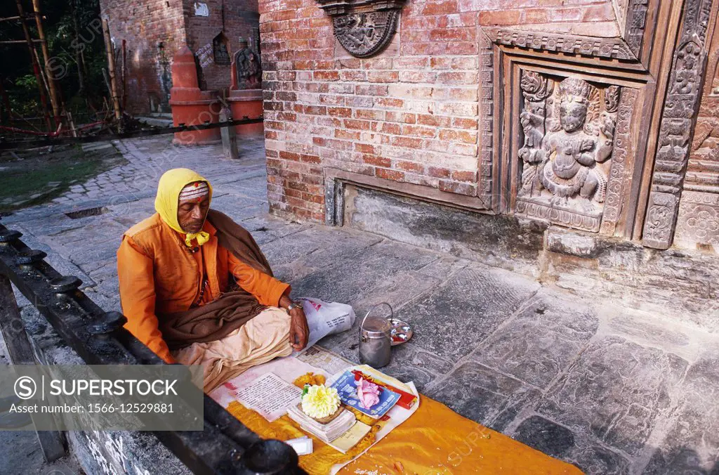 Hindu priest reading a hindu text in front of a temple ( Kathmandu valley, Nepal).