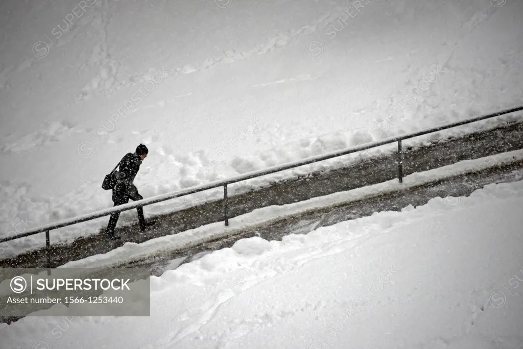 single man walking up the road in heavy snowfall, Geneva, Switzerland