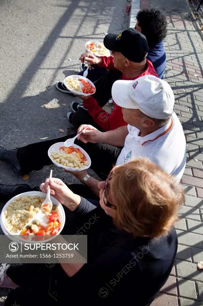 Group of people eating crumbs  The crumbs are a traditional meal and delicious Andalusian  The Festival of the Crumbs in Torrox  Malaga, Andalusia, Sp...