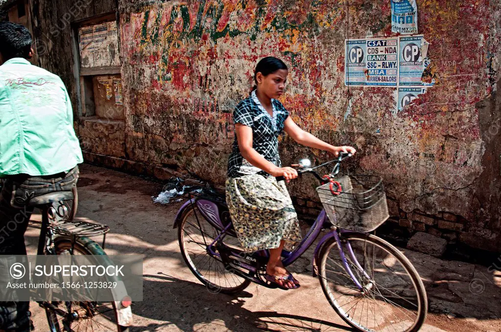 Girl riding a bicycle on the streets of Puri  Orissa, India