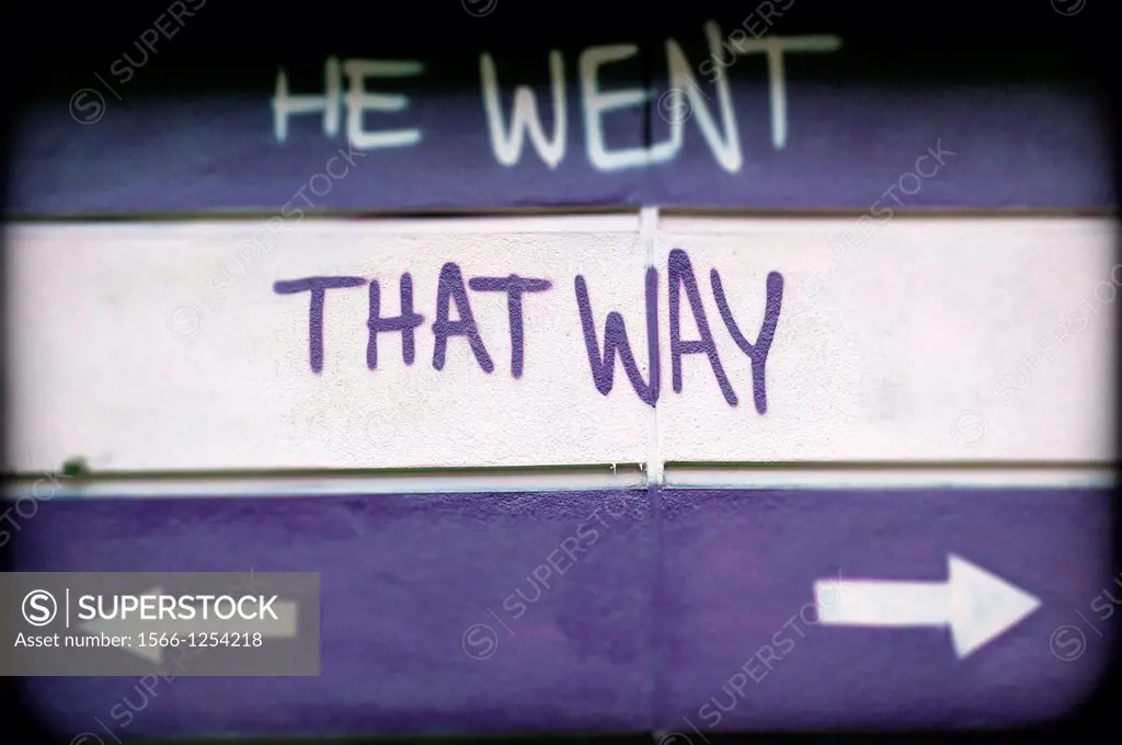 flechas con texto, He Went That Way, en una pared de la calle de East London, England, UK, arrows with text, He Went That Way, on a street wall in Eas...