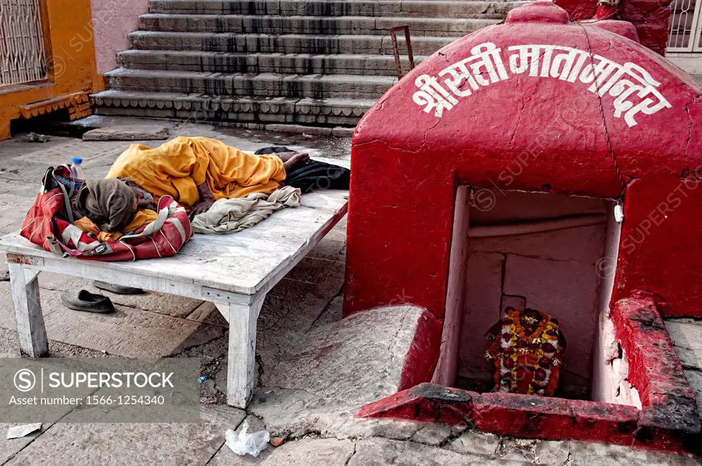 Shadu sleeping next to a shrine in a ghat  Varanasi, Benares, Uttar Pradesh, India