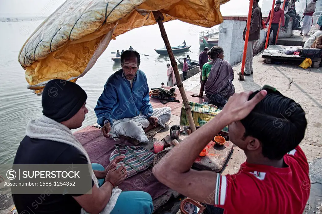 Brahmin sitting under an umbrella at the Ganges riverbanks  Benares, Varanasi, Uttar Pradesh, India