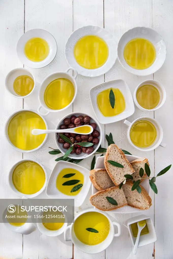 Presentation of wholemeal bread and olives with olive oil.