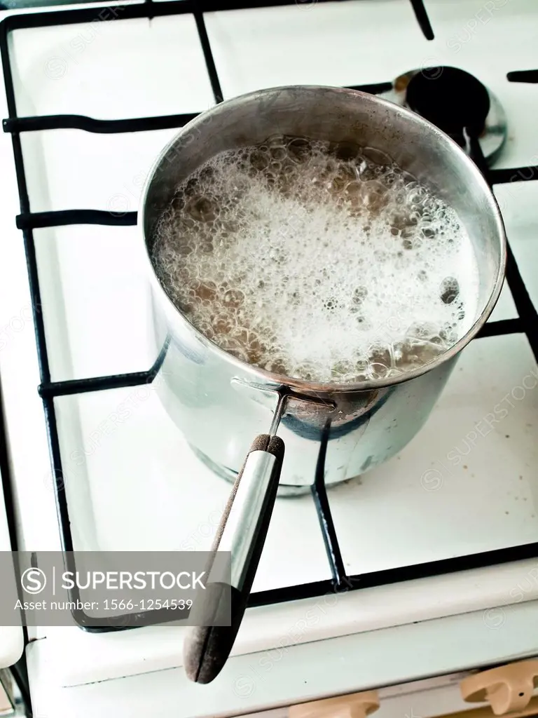 Gas stove. Water boiling inside a pot.