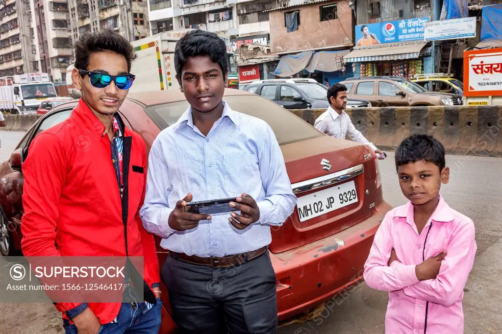 India, Asian, Mumbai, Dharavi, 60 Feet Road, slum, man, teen, boy, fashion,  sunglasses. - SuperStock