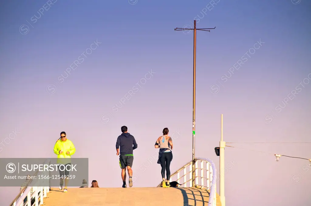 People running down a bridge, doing outdoor sports. Barcelona, Catalonia, Spain.