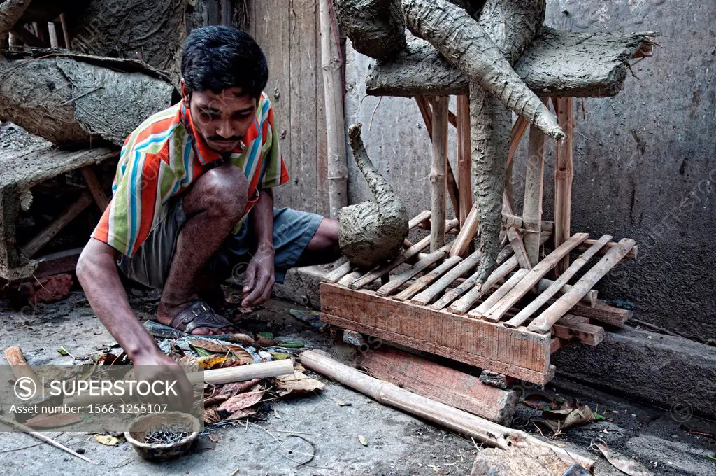 Man making effigies of gods in a workshop in Kumartuli district, Calcutta, West Bengal, India