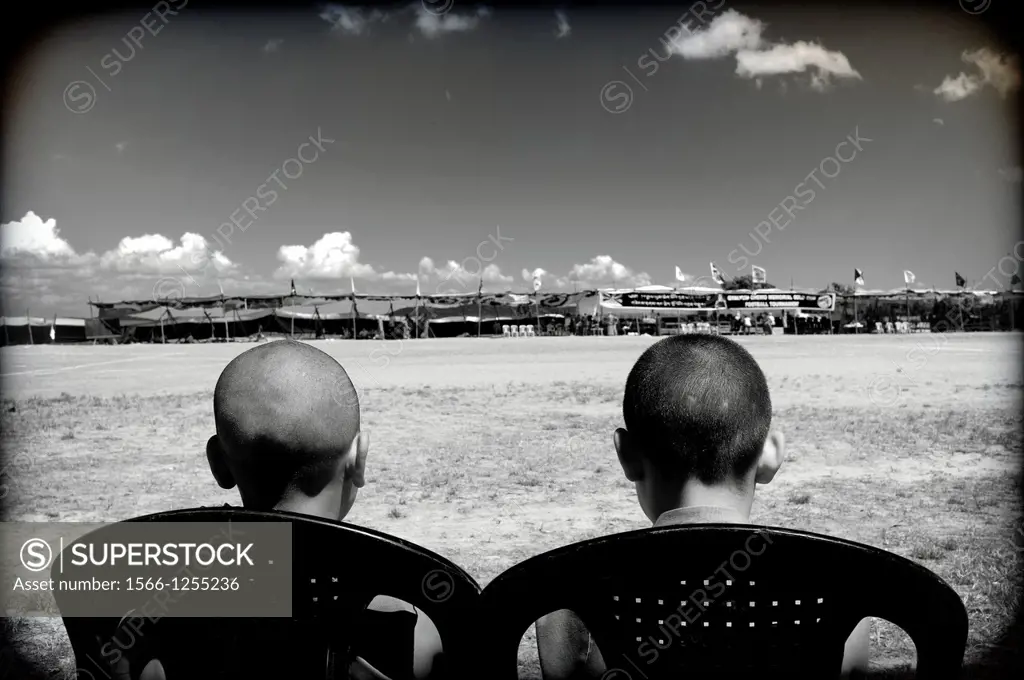 Dos jovenes sentados de espaldas mirando un partido de futbol en Mundgod, Karnataka, India, Asia, Two young men sitting back watching a football match...