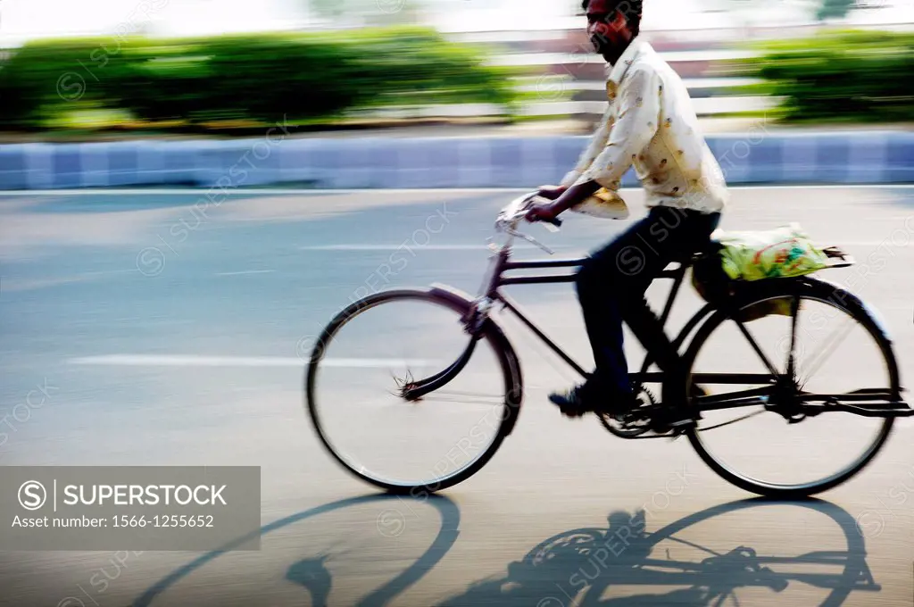 hombre en bicicleta por una carretera en India  man cycling along a road in India, Asia