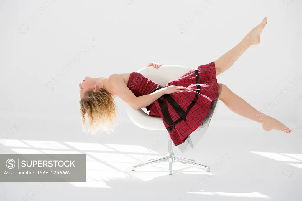 Fashionable young woman posing in a modern chair
