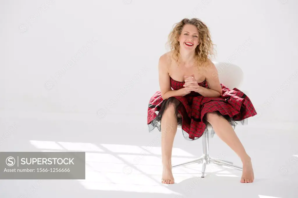 Fashionable young woman posing in a modern chair