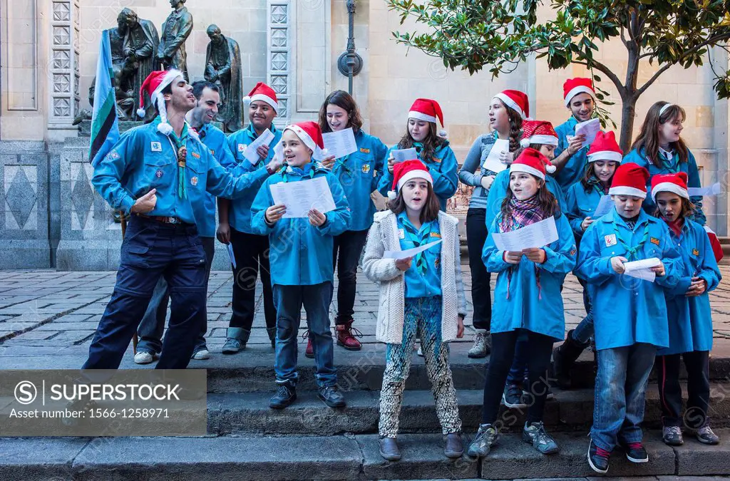 Boy scouts singing christmas carols in Bisbe street to raise money,during Christmas time  Barcelona  Catalonia, Spain