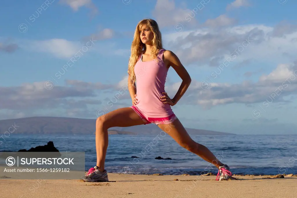 A healthy, fit woman exercises at the beach at Wailea, Maui, Hawaii