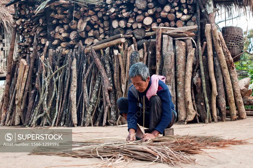 Akha man preparing thatch for home repair, Phongsaly, Laos