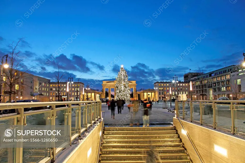 Berlin Brandenburg gate with christmas tree and snow at dusk and underground stairs