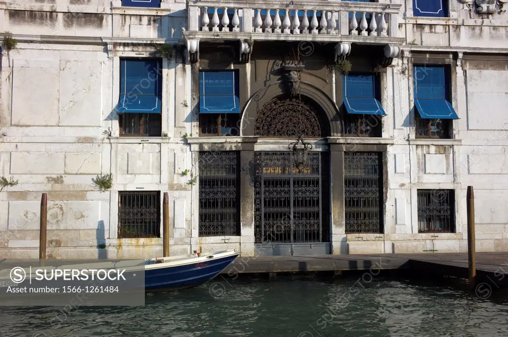 A small boat docked in front of old Venetian architecture