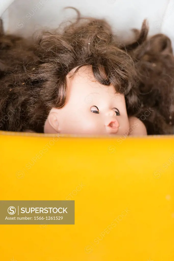 Head of toy doll with open mouth and brown hair