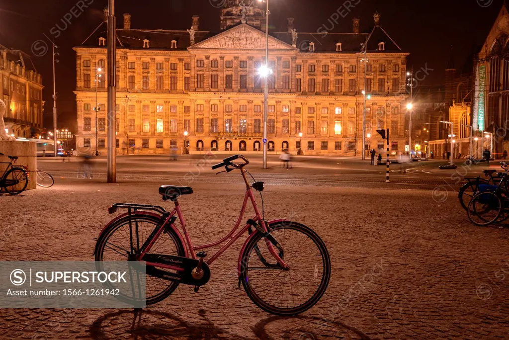 royal palace at the Dam in Amsterdam by night with grandma bicycle, The Netherlands