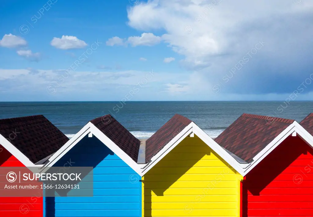 Whitby, North Yorkshire, England, United Kingdom. Europe. View over beach huts as storm clouds pass over North Sea.