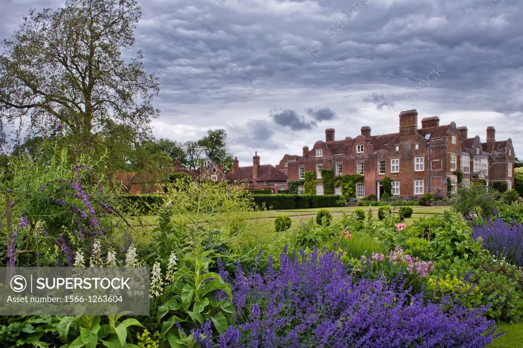View of the garden across the herbaceous summer borders towards the house, Godinton House and Garden, Kent England.