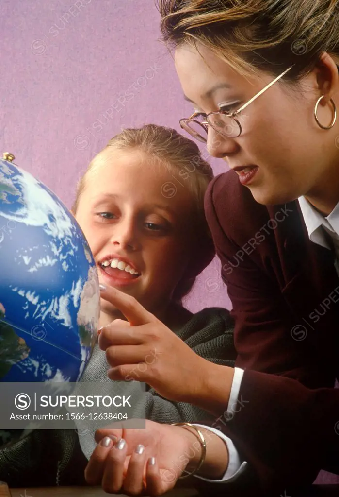 teacher and student looking at globe.