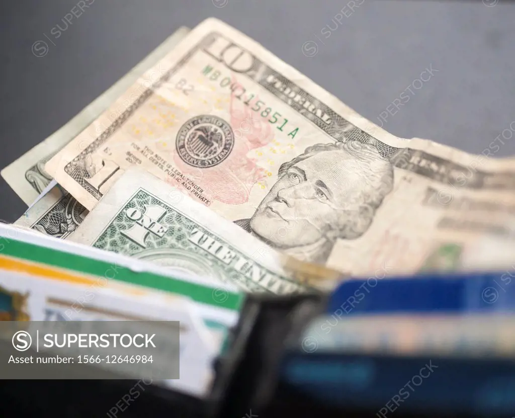 A US ten dollar bill with Alexander Hamilton is seen amongst other bills poking out of a wallet in New York. The US Treasury Dept. announced that the ...