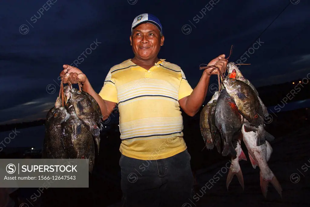 Fisherman with fish in Tabatinga port. Amazonas river (Brazil).