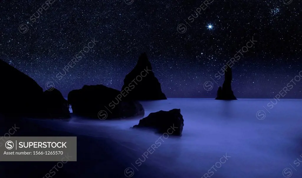 Starry night sky and Reynisdrangar cliffs, South Coast, Iceland digital composite