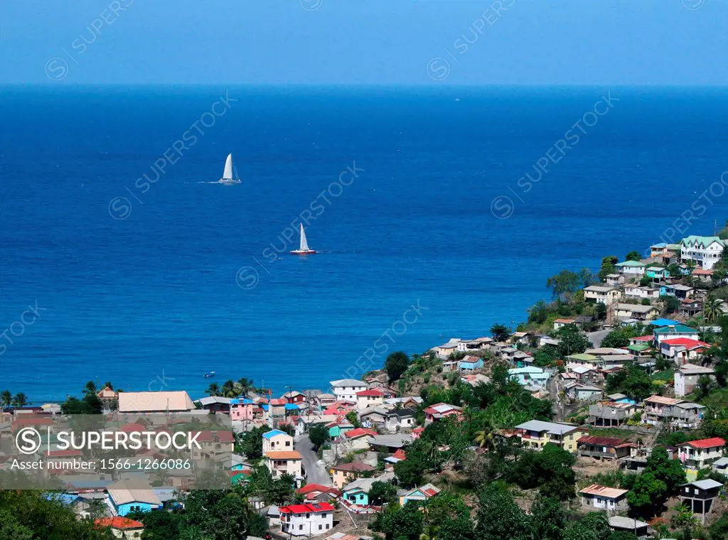 Sailboats plying the warm blue waters off a picturesque Caribbean fishing village