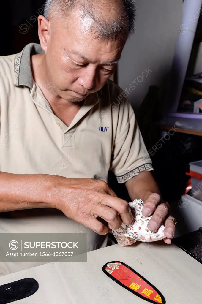 Artisan making shoes for ""bound feet"". Foot binding is a banished practise held in ancient China, consisting in applying a tight binding to the feet...