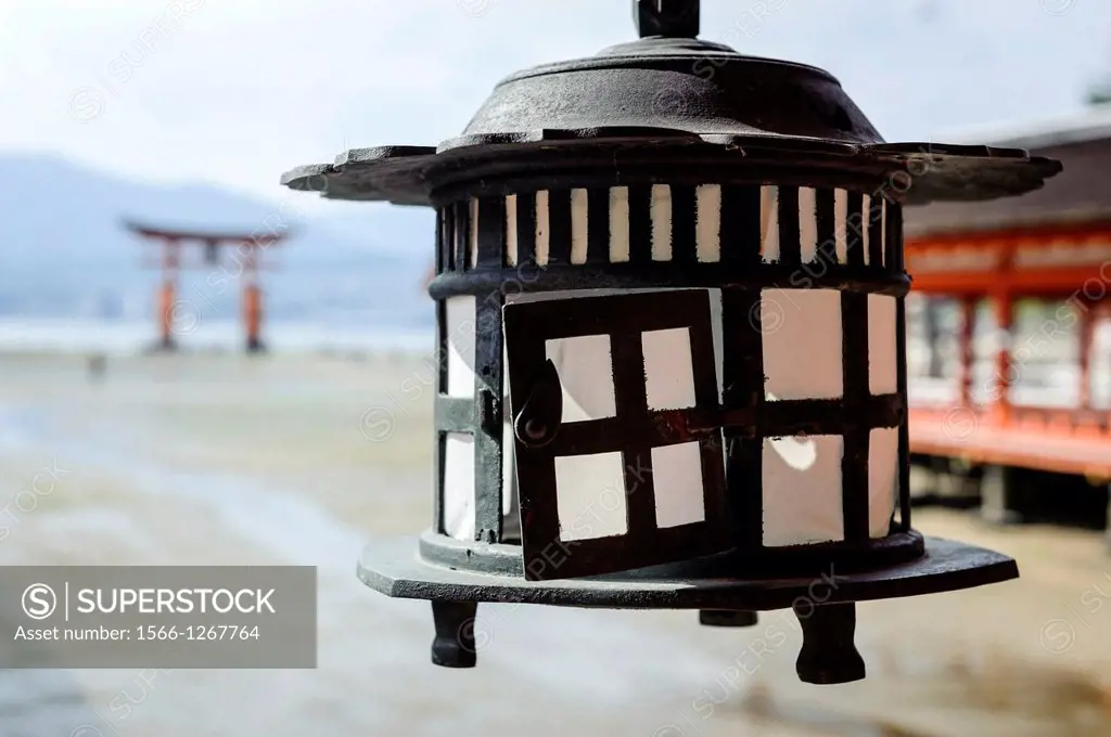 Detail of a lantern with the Grand Torii in the background, Itsukushima sanctuary, Japan