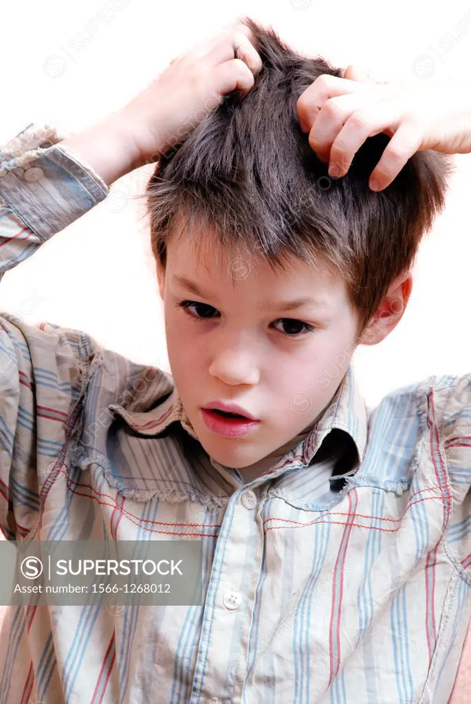 Boy scratching his scalp to relieve the irritation caused by head lice.