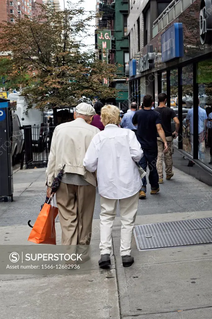 Very Elderly Unidentifiable, Man and Woman Couple, Walking along a Manhattan, New York City Street.