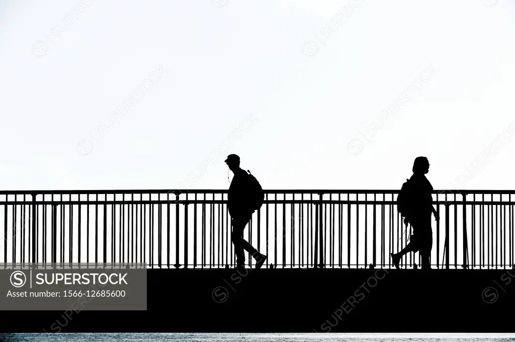 The silhouette of people walking across the Louisa Gap Bridge in Broadstairs, Kent.