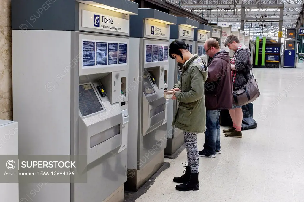 Passengers buying rail tickets at an automatic ticket machine on the platform, Glasgow Central Railway Station, Glasgow, Scotland, UK.