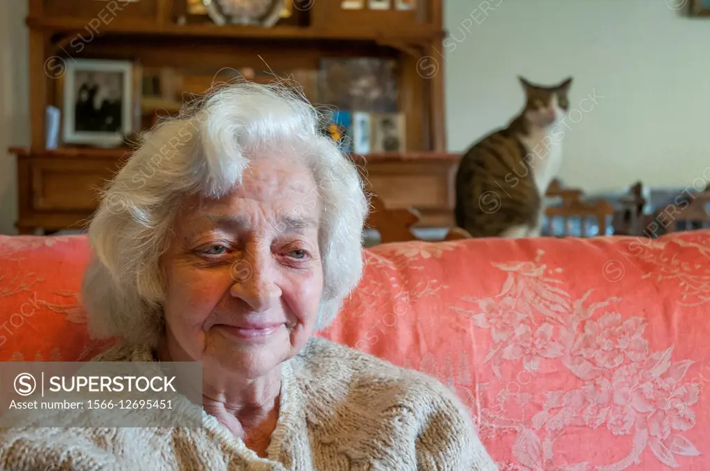 Happy old woman at home with her cat.