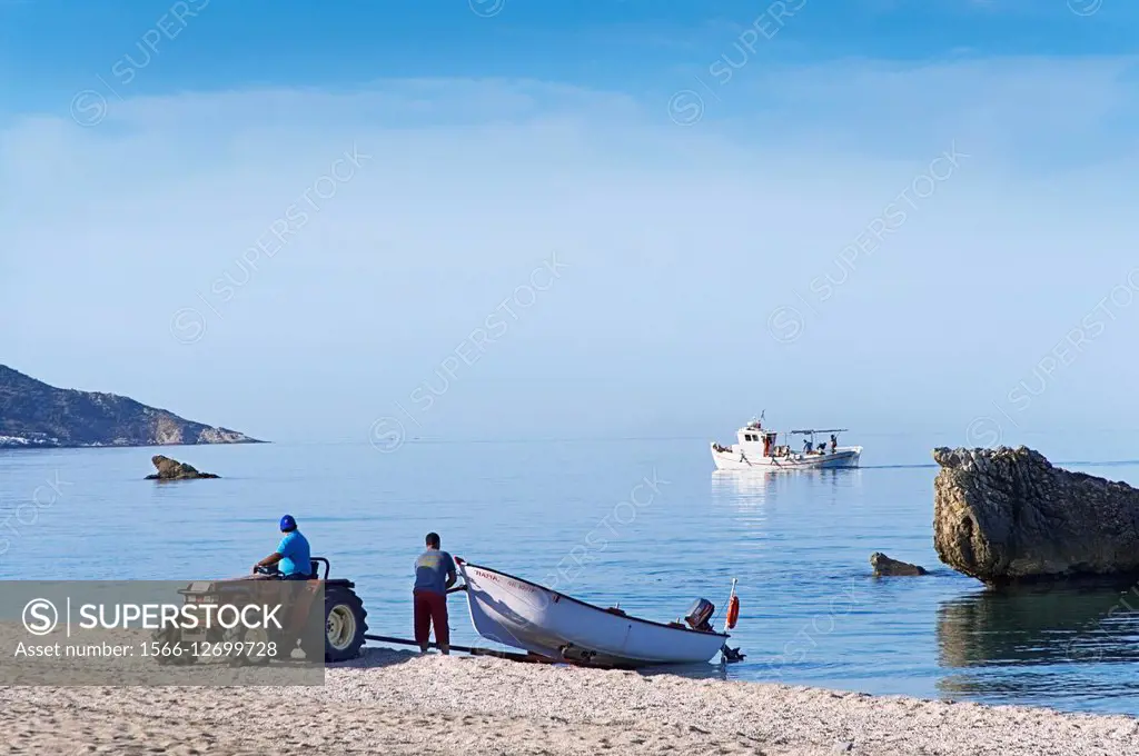 Fishermen launching their boat (Pelion Peninsula, Thessaly, Greece).