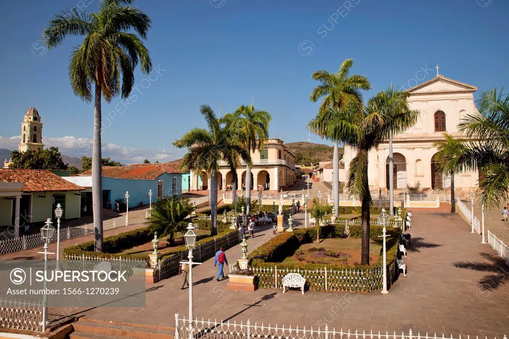 square Plaza Mayor with the Church of the Holy Trinity, Museo Romantico and bell tower of the Convento de San Francisco and on the in Trinidad, Cuba, ...