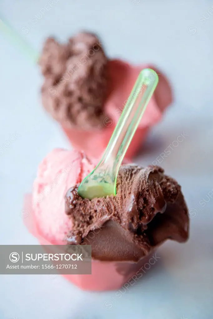 Two strawberry and chocolate ice-creams in a cup