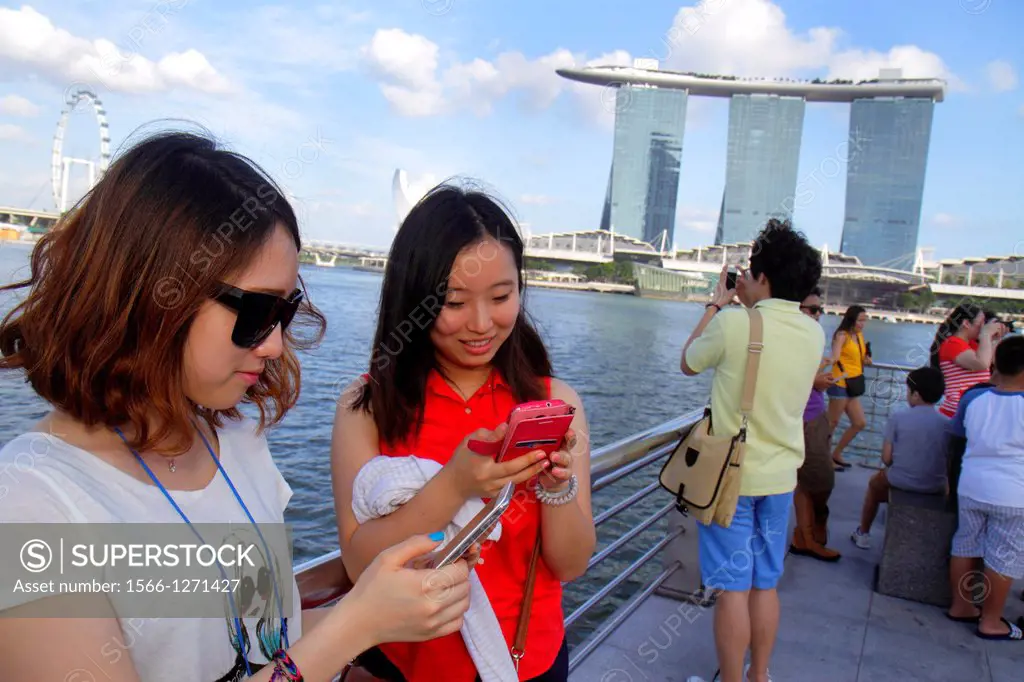 Singapore, Singapore River, Marina Bay, Merlion Park, Asian, woman, looking at, smart phone, Marina Bay Sands Integrated Resort, Skybridge, The Shoppe...