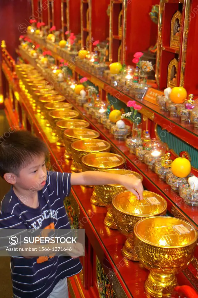 Singapore, Chinatown, Buddha Tooth Relic Temple and & Museum, shrine, religious, Asian, boy, donating, coins, putting into, vessels, urns, gold,