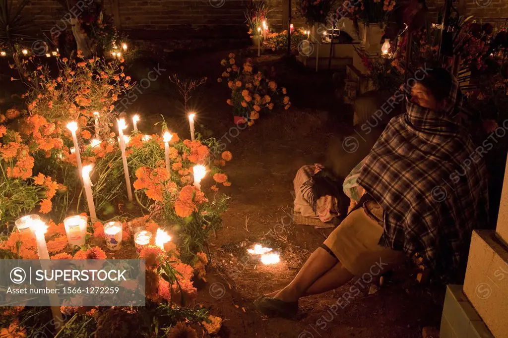 Woman attending an all-night vigil at grave of loved one during Day of the Dead in Atzompa, Oaxaca, Mexico.